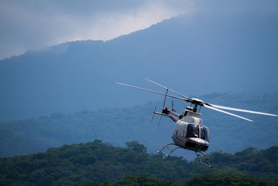 helicopter flying over lush hills